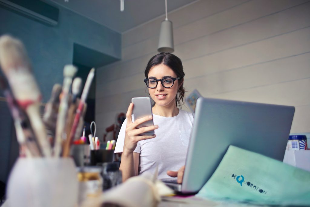 young woman is taking a video of art supplies with her cellphone